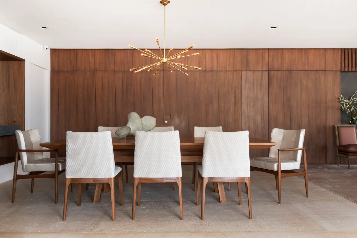 Sala de jantar do Apartamento Alto de Pinheiros com madeira natural e luminária escultural