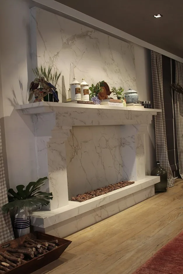 Detalhe da lareira clara com objetos decorativos, plantas e lenha em bandeja