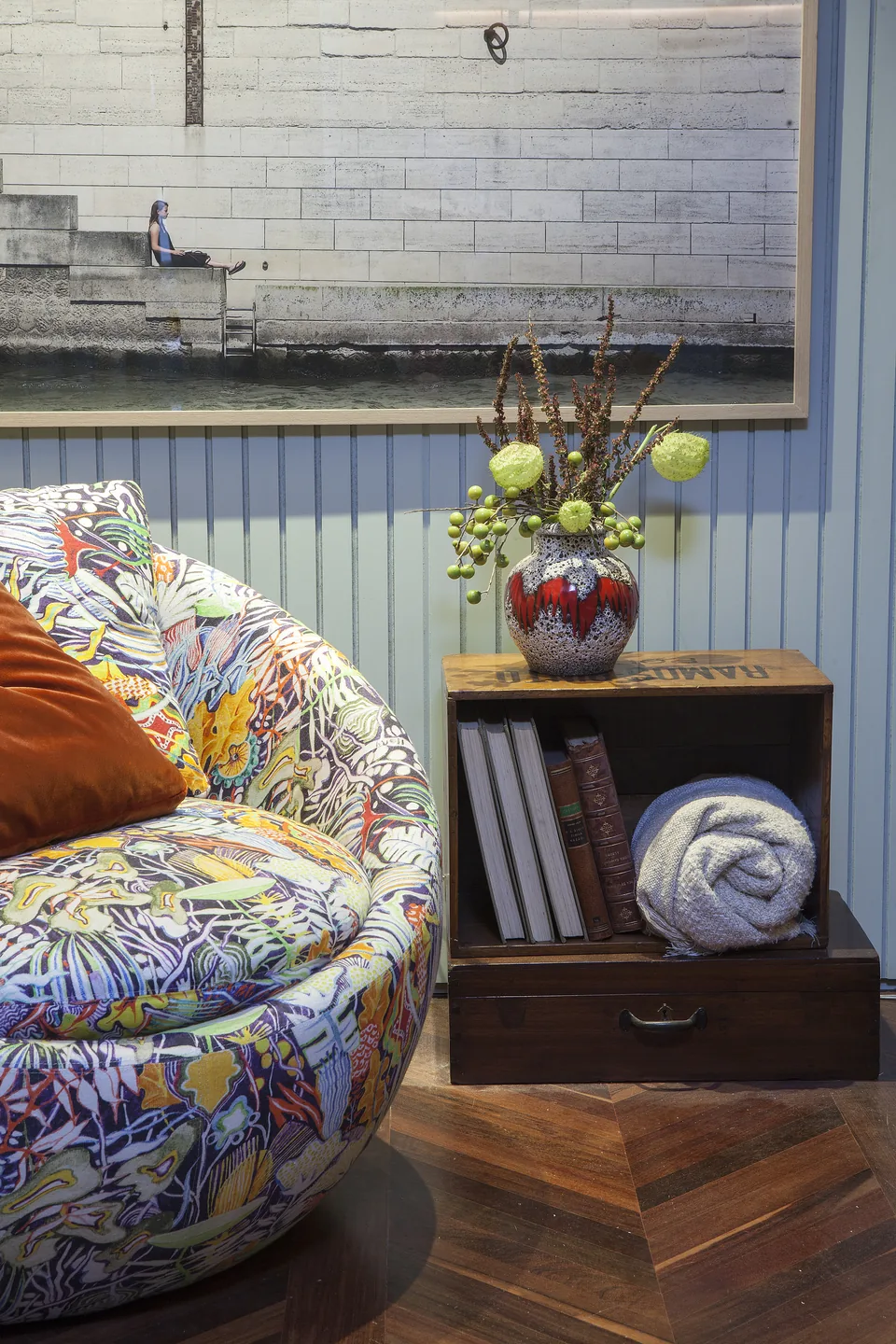 Detalhe da poltrona estampada com mesa de apoio e arranjo de flores