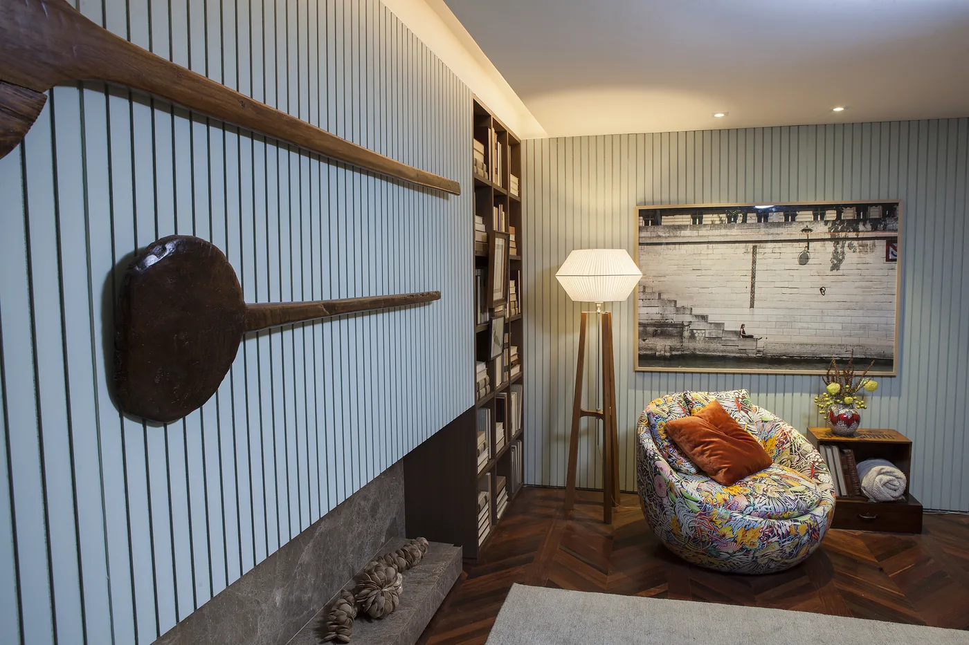 Canto da Sala de Almoço com poltrona estampada, luminária de piso e estante