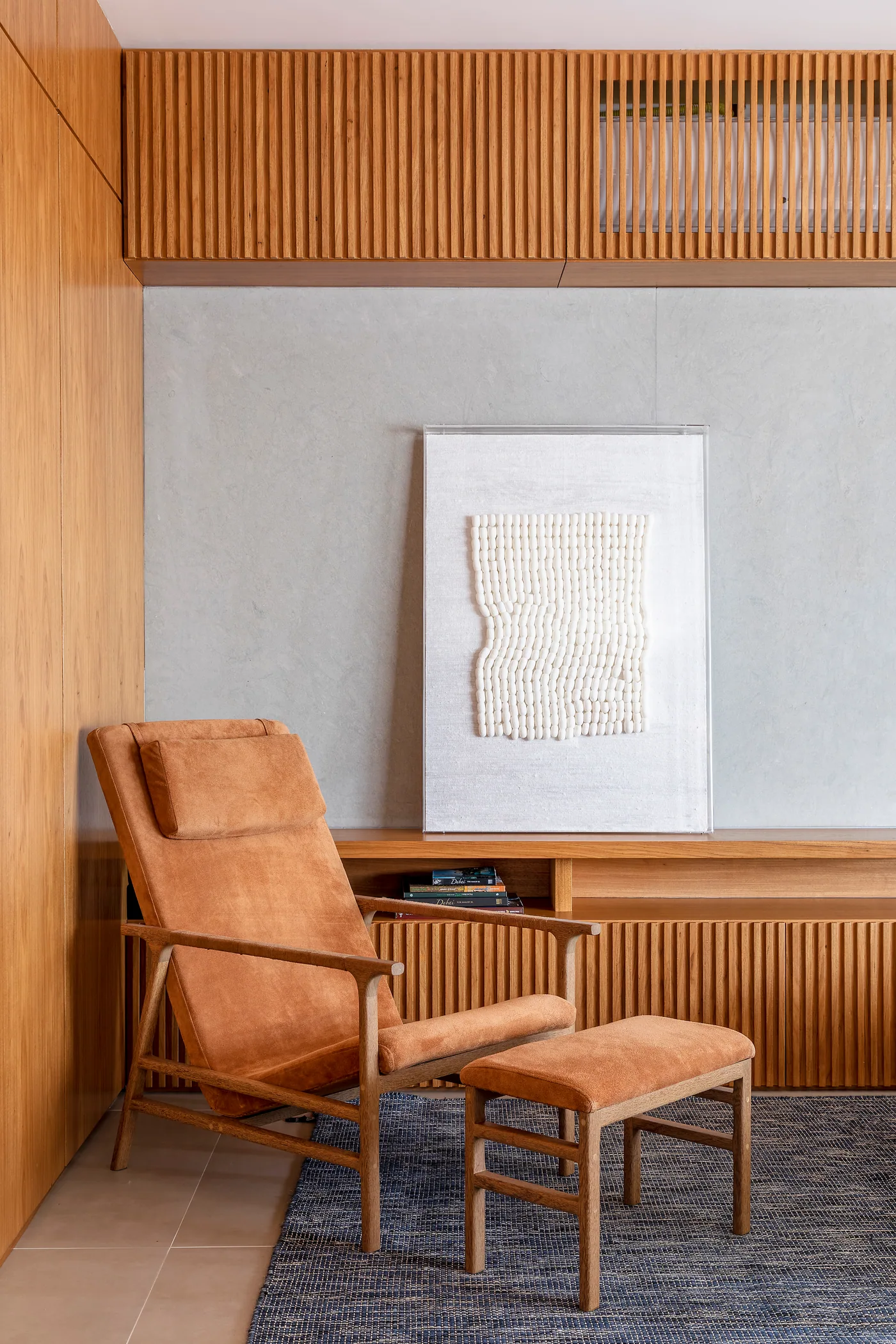 Sala da cobertura com painel ripado, sofá, mesa central e vasos decorativos
