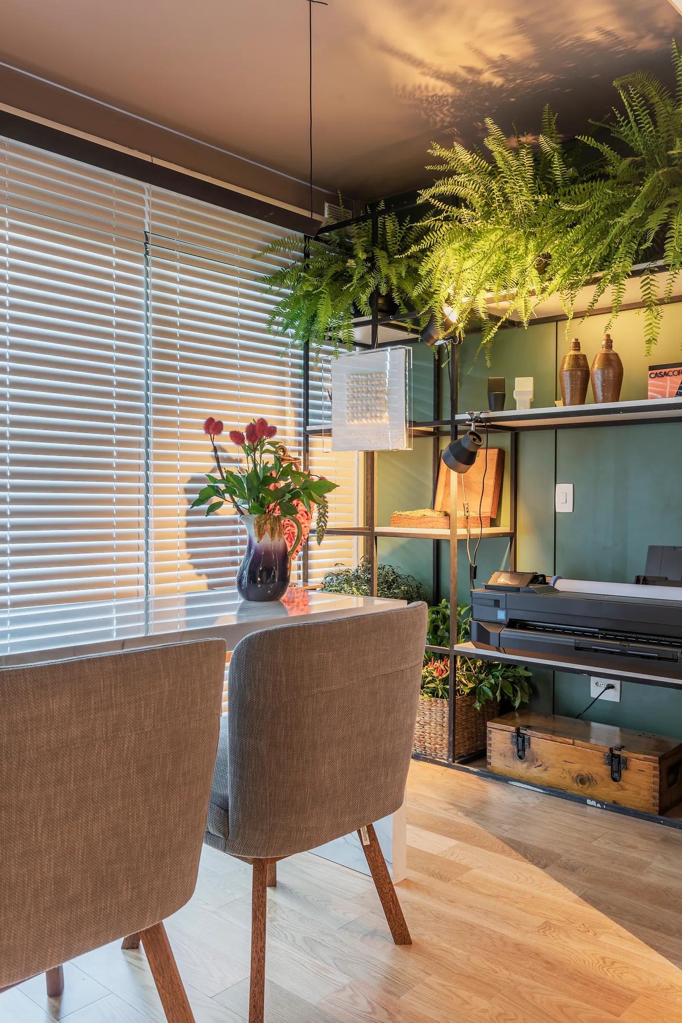 Área de trabalho do escritório com mesas, poltronas e tons de verde