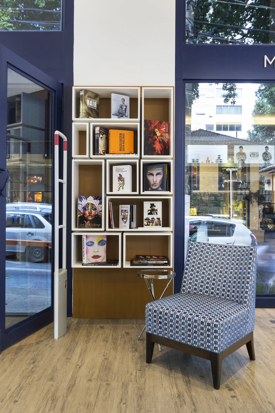 Estante com livros e objetos curatoriais na Kryolan Flagship.