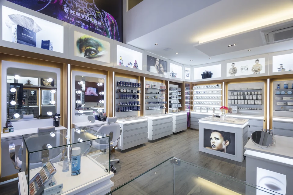 Ambiente da Kryolan Flagship com espelhos iluminados, displays de produtos e comunicação da marca.