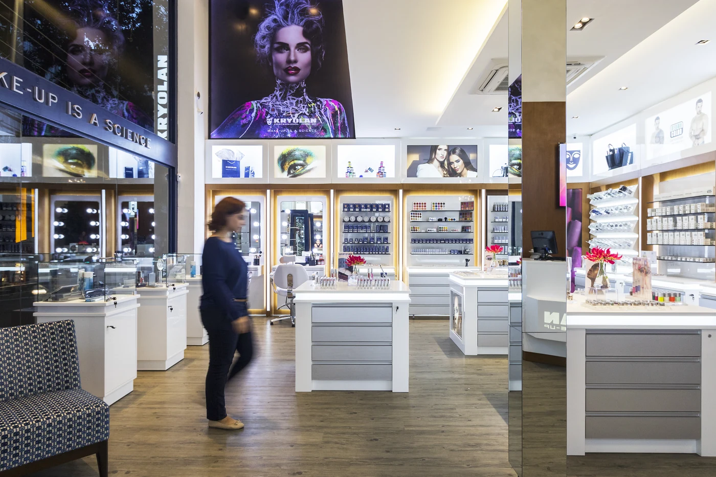 Interior da Kryolan Flagship com espelhos, displays de produtos e circulação em primeiro plano.