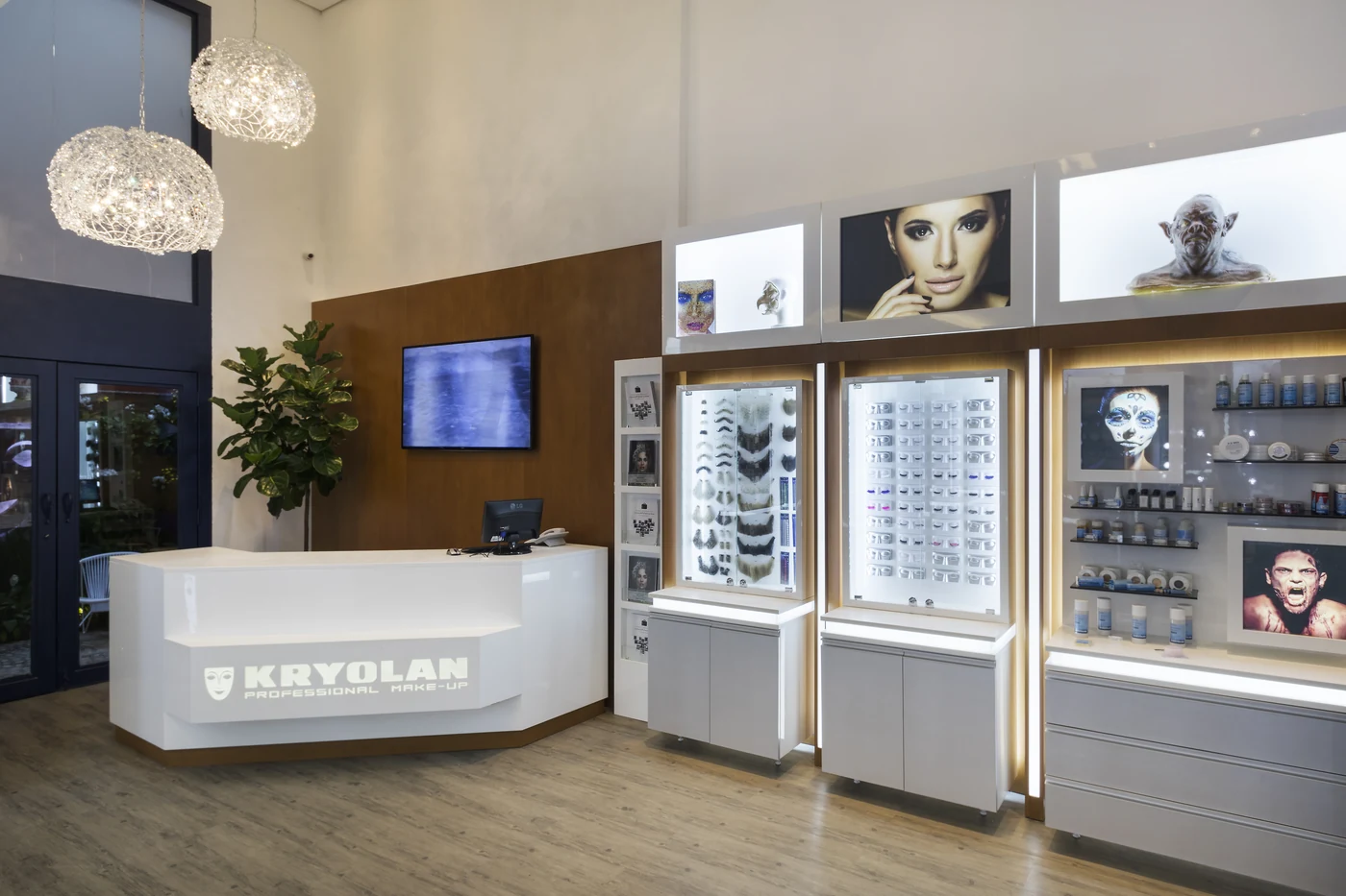Recepção da Kryolan Flagship com balcão branco e expositores iluminados.