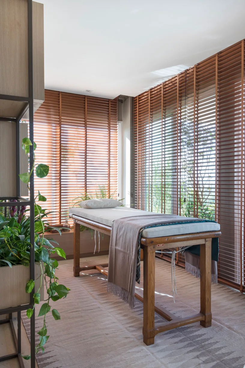 Estante metálica com caixas de madeira clara, plantas e objetos no spa residencial