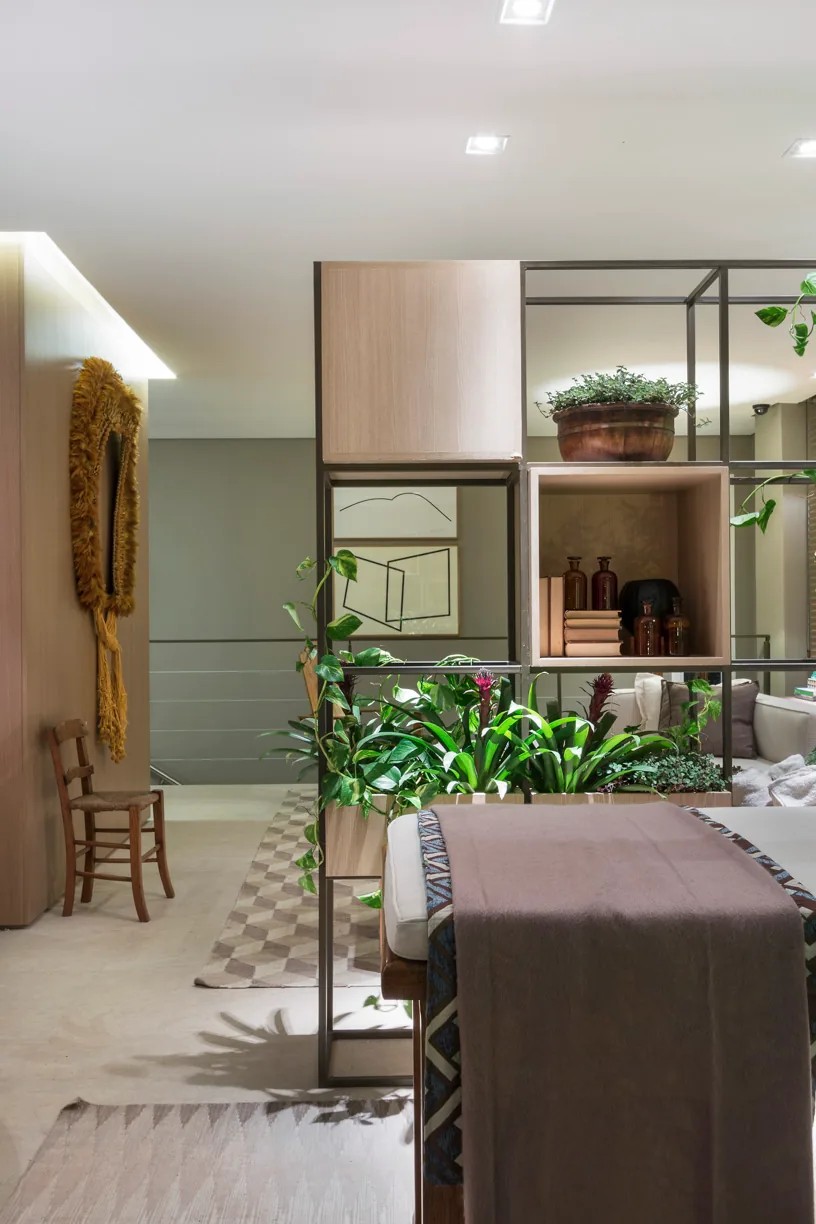 Detalhe do spa com estante metálica, madeira clara, plantas e maca