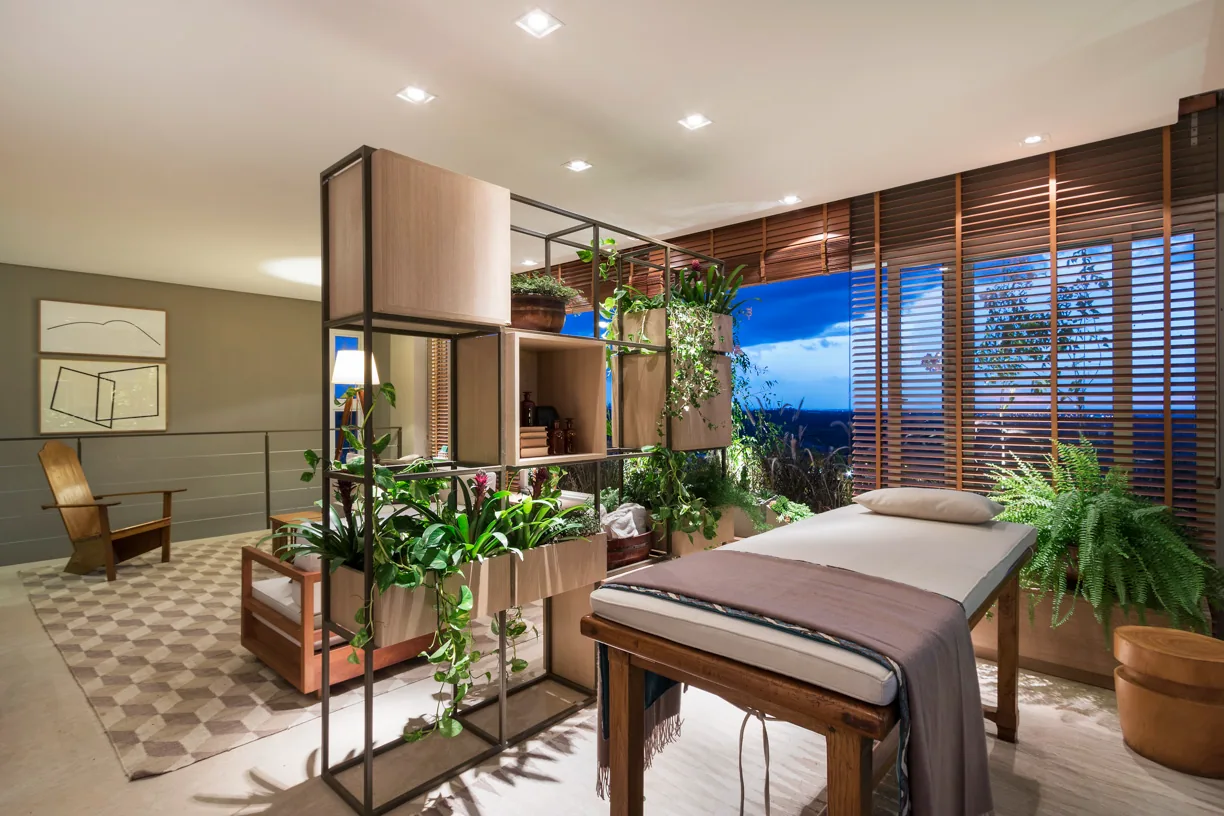 Área de spa da residência em Campinas com vegetação, persianas de madeira e maca de massagem