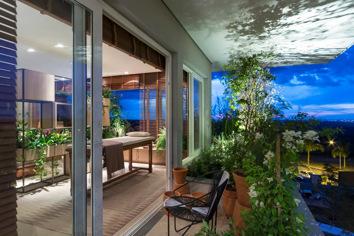 Varanda noturna integrada ao spa com vista aberta, plantas e iluminação cênica